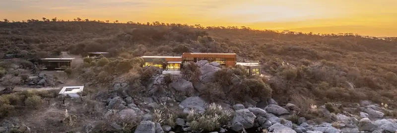 Casa en Piedras on a rocky hillside at sunset