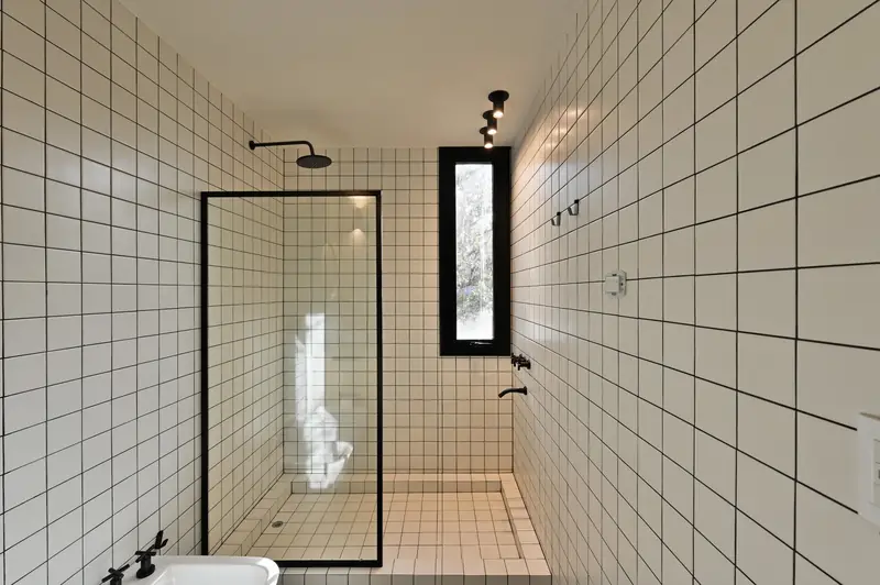 White grid-tiled bathroom with walk-in shower, Casa en Piedras