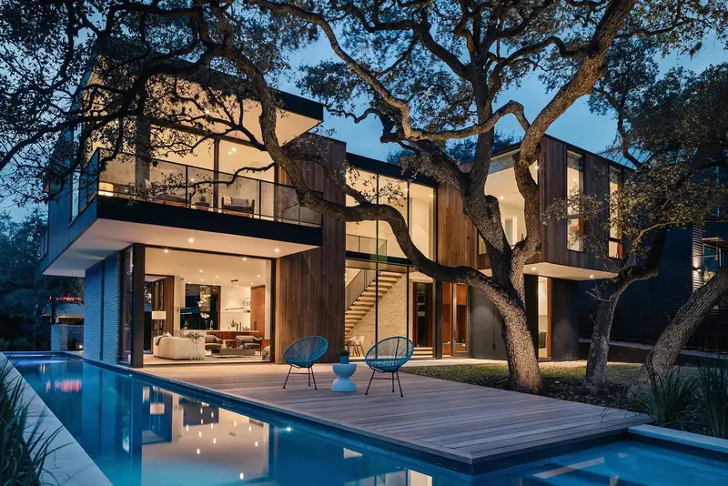 Casa Retama at dusk beneath mature oak trees, with pool