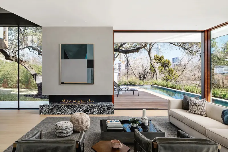 Living room with fireplace and glass walls to the trees, Casa Retama