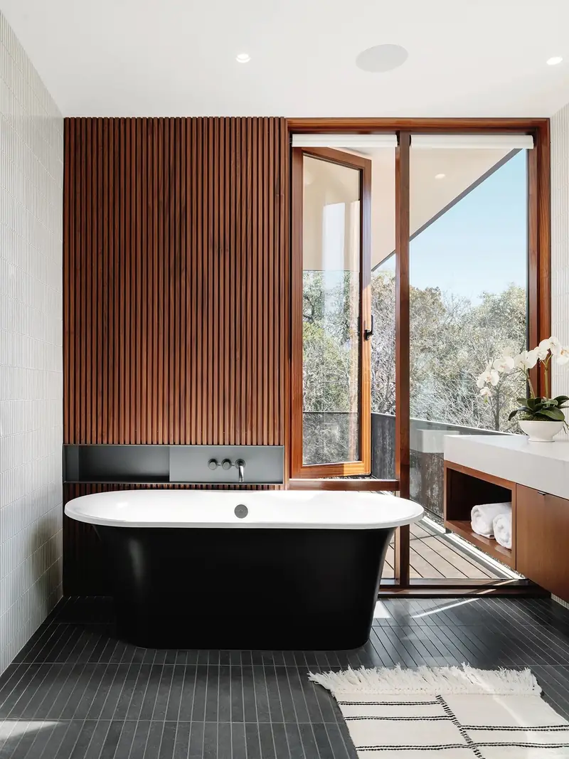 Black soaking tub in a wood-lined bathroom, Casa Retama